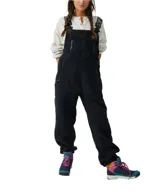 Mono de poliéster negro con textura de polar, tirantes ajustables con logo y hebilla, bolsillos delanteros y traseros con cierre.