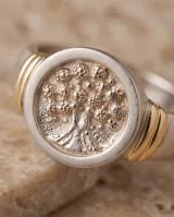 Anillo de plata 925 con lámina de oro de 18k y diseño circular grabado con motivo de árbol.