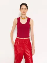 Top color borgoña de hilado frío, corte ajustado y largo hasta la primera cadera. Sin mangas, con cuello redondeado y profundo.