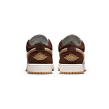 Championes Nike Air Jordan 1 Low SE, con diseño en tonos marrón, blanco y detalles en beige. Presenta cordones verdes con motas blancas y suela de goma color caramelo.