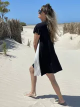 Vestido corto negro con panel lateral blanco, de corte holgado y mangas cortas con volados.