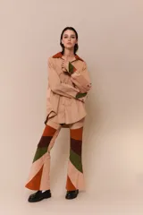 Pantalón acampanado de pana color beige con parches de pana marrón, verde y naranja.