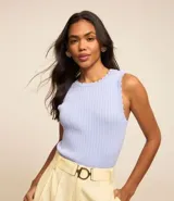 Blusa sin mangas de punto leve en color celeste, con cuello redondo y textura acanalada. Presenta terminaciones onduladas tipo nube en el cuello y las sisas.