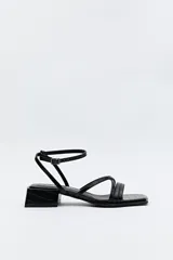 Sandalia negra con taco medio cuadrado y tiras finas con textura símil reptil. Pulsera al tobillo con hebilla metálica.