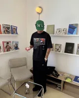 Remera negra de corte oversize, confeccionada en algodón, con estampa fotográfica central de una jugada de fútbol y texto alusivo al candombe.