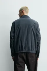 Sobrecamisa regular fit confeccionada en tejido fluido con mezcla de lyocell de la colección Origins. Posee cuello solapa, manga larga con puño abotonado, bolsillos frontales con solapa, bolsillos laterales ocultos y cierre frontal de cremallera bidireccional.