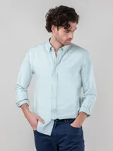 Camisa celeste a rayas verticales blancas, de corte regular fit, con cuello button-down, cierre con botones, manga larga terminada en puño simple y logo bordado en el pecho.