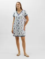 Camisón corto de tejido soft, color blanco con estampado floral y de hojas en tonos azules y marrones. Cuenta con mangas cortas y escote en V con terminaciones de encaje azul en el cuello, las mangas y el ruedo.