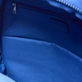 Mochila de tela arrugada color azul, con múltiples compartimentos con cierre, bolsillos laterales y logo circular grabado en el frente.
