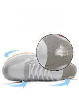 Zapatillas deportivas de estilo retro, combinando paneles de malla negra, gamuza negra y cuero sintético negro. Cuentan con cordones negros, forro interior blanco y un cuello acolchado con detalle plateado en el talón. La suela es gruesa y blanca con una banda de rodadura negra.