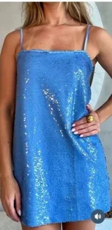 Vestido corto azul con lentejuelas, de corte recto y breteles finos.