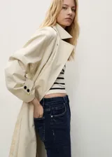 Jeans de corte flare y tiro alto, color azul oscuro, con diseño crop y terminación deshilachada en los tobillos. Cuenta con cierre de cremallera y botón, trabillas para cinturón y cinco bolsillos.