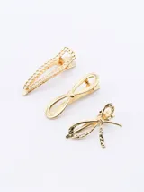 Set de tres broches dorados para el pelo con diferentes diseños: uno con forma de cadena, otro con forma de moño simple y otro con forma de moño texturizado.