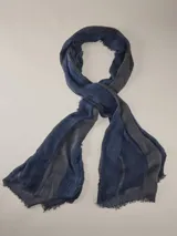 Chalina gris y azul marino, confeccionada en tejido liviano con bordes desmechados y diseño a rayas.