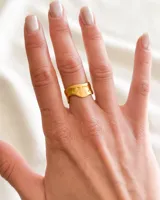 Anillo dorado de acero con diseño irregular.