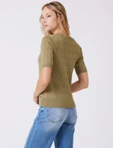 Buzo tejido marca Tahari, color verde, con cuello a la base, manga corta y diseño de ochos en el frente.