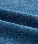 Pantalón de jeans de tiro alto, color celeste desgastado, modelo wide leg (pierna ancha) con cierre y botón metálico.