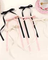 Par de hebillas para el pelo con moño de cinta de grogrén negro y tiras largas.