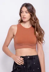 Top color ladrillo, sin mangas, de cuello redondo y tejido seamless con destellos metálicos.