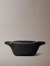 Riñonera negra Calvin Klein de poliuretano con monograma grabado en toda la pieza, correa ajustable y cierre superior con cremallera.