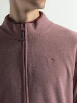 Campera de polar con cuello alto, cierre frontal completo y bolsillos laterales con cierre.