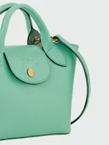 Cartera tipo shopper tamaño XS de la línea Épure de Longchamp, confeccionada en cuero de color verde menta. Presenta una estructura rígida, asas cortas superiores y un cierre de solapa con botón a presión metálico dorado.