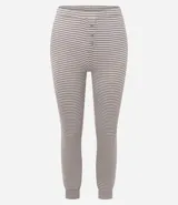 Pijama de dos piezas compuesto por una blusa de manga larga con cuello redondo y un pantalón con cintura elástica. Presenta un diseño de rayas horizontales en tonos gris y blanco.