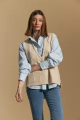 Chaleco tejido color azul, con escote en V, cierre frontal con botones y diseño de líneas verticales en relieve. Presenta terminaciones acanaladas en el ruedo y un borde ondulado en el escote.