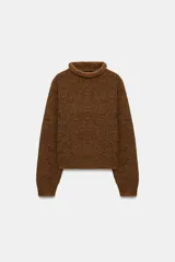 Jersey de punto con textura, cuello subido y manga larga, de corte recto y diseño clásico.