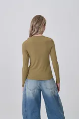 Remera de manga larga ajustada al cuerpo, color blanco, con cuello redondo bajo y tejido acanalado.