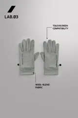 Guantes de running negros, ligeros y ajustados, confeccionados en tejido técnico con mezcla de lana. Cuentan con función táctil en los dedos y un enganche lateral de seguridad para unirlos.