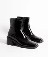 Botín de cuero con estampado de piel de serpiente en tonos blanco y negro, con puntera cuadrada y tacón bloque bajo.