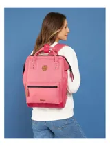 Mochila Cabaia modelo Adventurer Venise, color rosado con base fucsia. Cuenta con un bolsillo frontal con cierre, asas superiores y correas acolchadas. Incluye un parche redondo con logo en la parte superior y un parche rectangular con logo en la parte inferior.