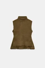 Top de punto color verde militar, con cuello subido y manga sisa. Presenta apliques dorados en los laterales y un bajo asimétrico.