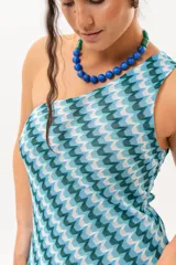 Vestido largo de un solo hombro con estampado geométrico en tonos azules, celestes y verdes, de corte fluido.