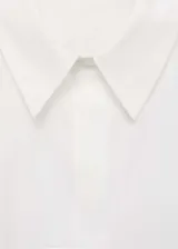 Camisa crop de popelín con cuello camisero, cierre frontal de botones ocultos y mangas largas con puños anchos abotonados.