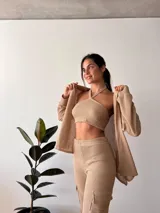 Camisa tejida color beige, de manga larga y corte holgado.