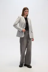 Blazer gris con cuello solapa, bolsillos frontales y cierre con dos botones.