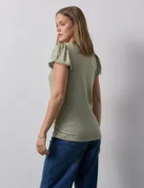 Remera tejida con estampado animal print, de manga corta con detalle de puntilla en las mangas y cuello redondo.