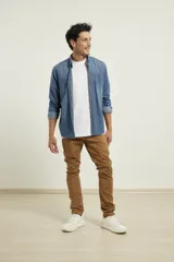 Camisa de hombre de denim azul, manga larga, con cuello buttondown y un bolsillo de parche en el pecho izquierdo.