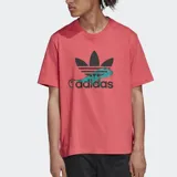 Remera rosa de corte clásico con logo Adidas en el frente que incluye el trébol y un diseño de un lagarto con anteojos.