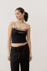 Musculosa de tejido rib color beige con detalles en marrón oscuro en el escote y doble tirante fino. Presenta un pequeño texto estampado en el pecho.