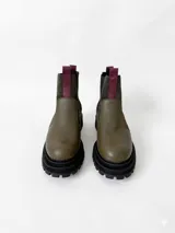 Botas tipo chelsea de cuero, combinando texturas en color bordó. Presentan paneles laterales elásticos en negro, suela track robusta y tiradores en la parte superior.