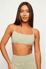 Top deportivo color verde claro, con breteles finos cruzados en la espalda y detalle de ribete blanco en el escote y bajo busto.