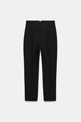 Pantalón tobillero de tiro alto y corte slim fit, con patrón de cuadros pequeños en tonos beige y negro. Presenta bolsillos delanteros de vivo y costuras marcadas en la parte delantera y trasera.
