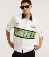 Camisa de manga corta color blanco con cuello en contraste negro, corte oversized, cierre frontal con botones y diseño estampado estilo deportivo de la marca Blue Steel.