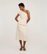 Pollera midi color crema, de corte evasé, confeccionada en tejido twill. Presenta un canesú sobrepuesto a la altura de la cintura.