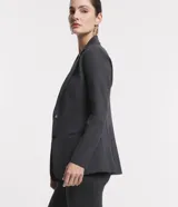 Blazer alargado color gris oscuro, con cuello solapa, bolsillos incorporados y cierre frontal con dos botones.