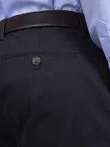 Pantalón de vestir azul marino, de corte recto, con bolsillos laterales y traseros. Se ajusta a la cintura con cinturón de cuero marrón.