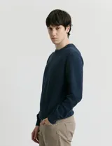 Sweater de punto con escote redondo, confeccionado en algodón con textura de punto fantasía en cuerpo y mangas, y terminaciones en punto canalé en cuello y puños.